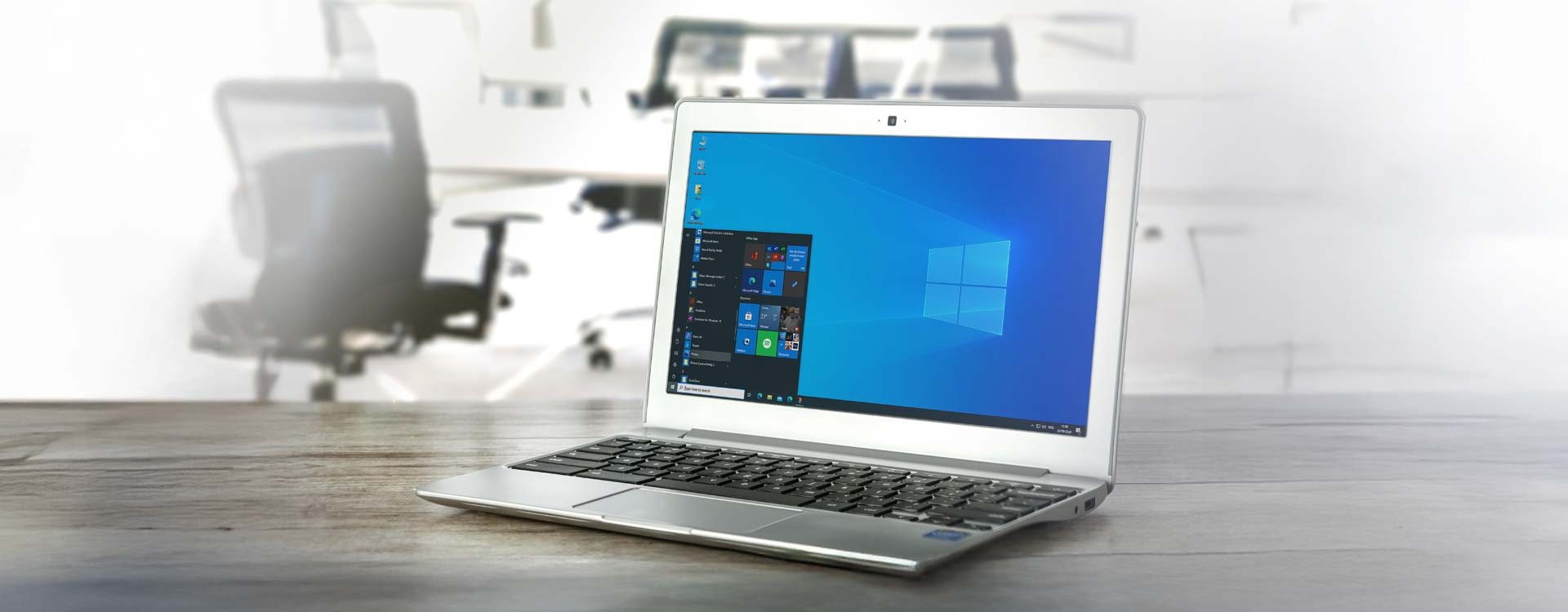 Microsoft - Laptop mit Microsoft-Screen auf einem Holztisch in einem Büro